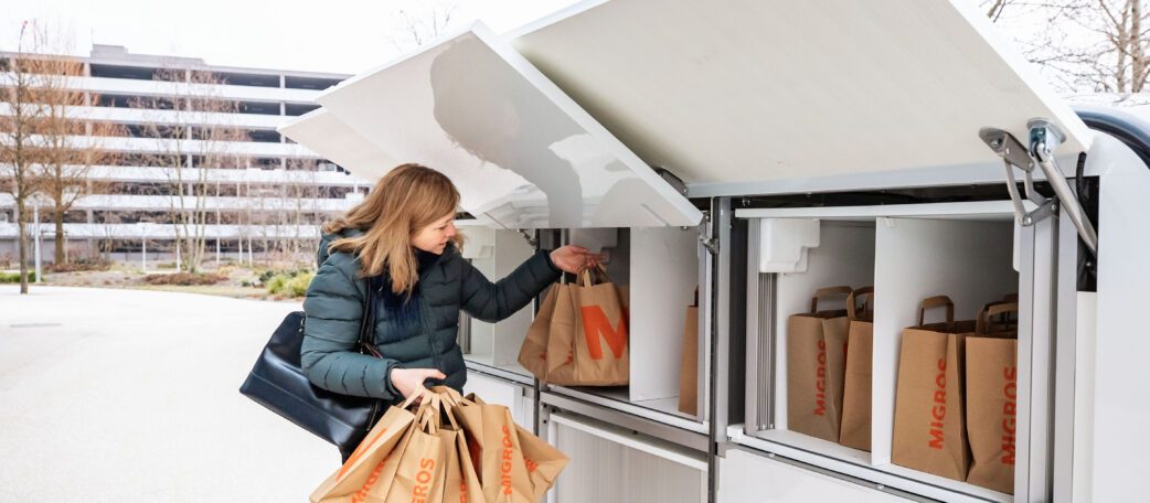 A woman is unloading her shopping from a LOXO Alpha vehicle