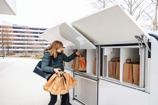 A woman is unloading her shopping from a LOXO Alpha vehicle